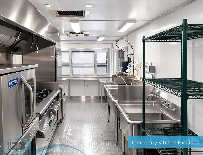 Temporary commercial kitchen trailer with triple sink, prep tables, shelving, and cooking equipment designed for efficient food service.