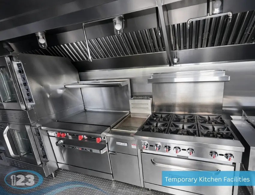 Commercial cooking line inside a mobile kitchen trailer featuring a gas range, flat-top griddle, ventilation hood, and professional food service equipment.