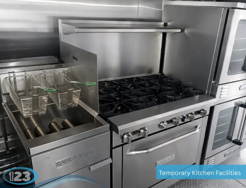 Close-up of a portable commercial kitchen trailer with deep fryer, six-burner gas range, and stainless steel cooking equipment for temporary food preparation.